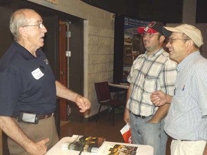 Larry Mitchell of James River Equipment, left, tells a story to Tyler and Ronald Seal, both are loggers in King and Queen County. Ronald said he liked the programs on biofuels and new emerging markets presented at the expo. -- Submitted 