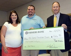 Melissa and Pastor Blake James of Mt. Carmel Christian Church in Carrsville with Dick Holland, president of Farmers Bank. The church received $556.50, which represents a dollar for each pound lost during the bank employees’ recent weight-loss competition. -- SUBMITTED