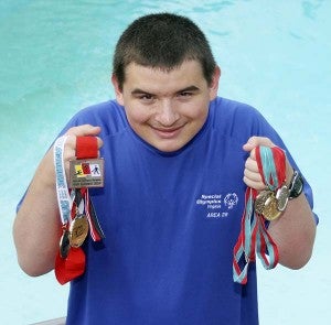 Jarratt holds up the medals that he has earned in Special Olympic events this year. -- CAIN MADDEN | TIDEWATER NEWS