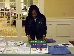Mynik Taylor, specialist at the American Cancer Society, sets up table with Relay for Life shirts. Photo by Andrew Lind.