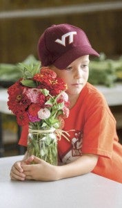 Andrew Hinson, 6, waits to enter flowers grown in the family garden.  -- FILE