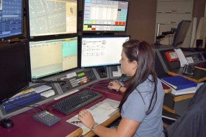 Dispatcher Shana Council listens to callers and type up information to relay to officers. -- Rebecca Chappell | Tidewater News