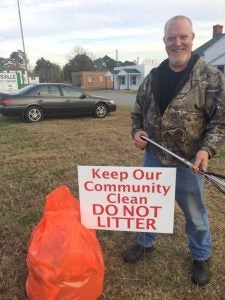 George Hasty of the Community Hunt Club displays one of six signs that are posted in Carrsvile asking people not to littler. His fellow club members plan to adopt adopted Harest Drive, and will also include five other roads in town. -- Stephen H. Cowles | Tidewater News